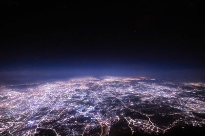 Aerial view of illuminated cityscape against sky at night