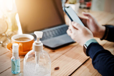 Close-up of man using laptop on table