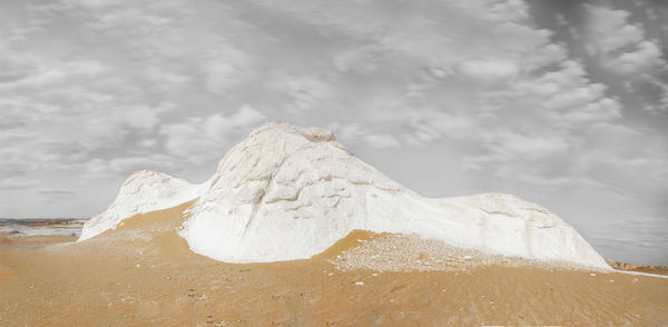 Umbrella on snow covered landscape against sky