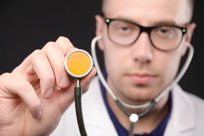 Close-up portrait of man holding eyeglasses