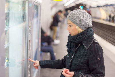 Side view of woman looking at train in winter