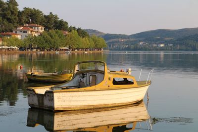 Boats moored in lake against sky