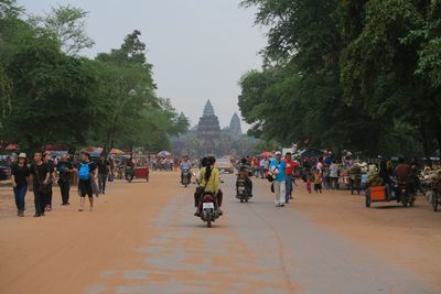 People at town square against sky in city