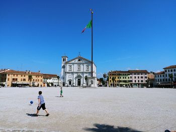 People in front of building against clear sky