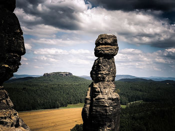 Stack of stones on land against sky