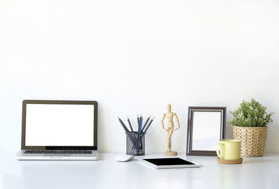 Close-up of laptop on table against white background