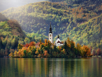 Scenic view of lake by buildings against mountain during autumn