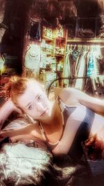 Portrait of young woman lying down on window