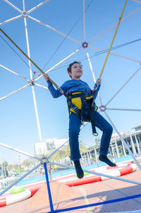 Low angle view of boy on swing