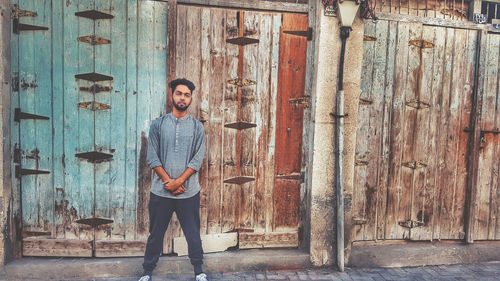 Portrait of man standing against wall