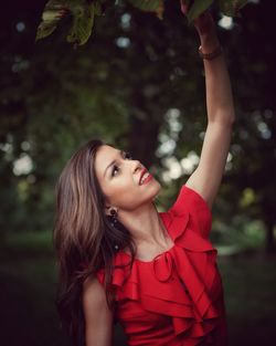 Portrait of young woman looking up outdoors