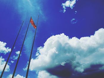 Low angle view of flag against blue sky