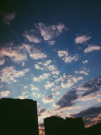 Low angle view of buildings against cloudy sky