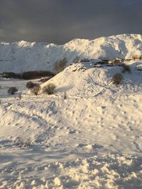 Snow covered land and mountains against sky