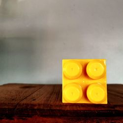 Close-up of yellow juice on table against wall
