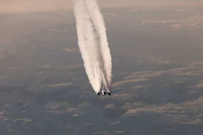 High angle view of airplane flying with contrail against sky