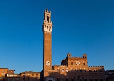 Siena, italy clock tower against blue sky