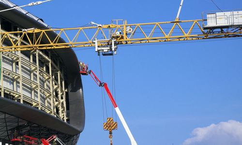 Low angle view of crane against blue sky