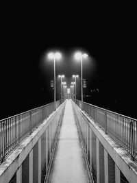 Illuminated street light against sky at night