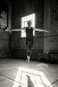 Full length of woman jumping against wall