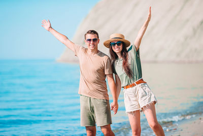 Full length of young woman wearing sunglasses against sea