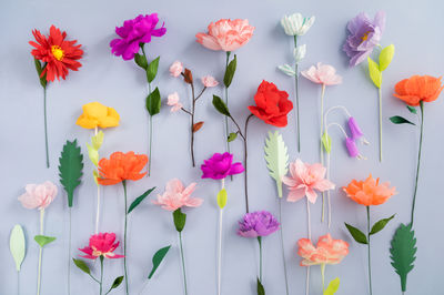 Close-up of colorful artificial flowers on gray background