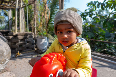 Portrait of cute boy holding hat