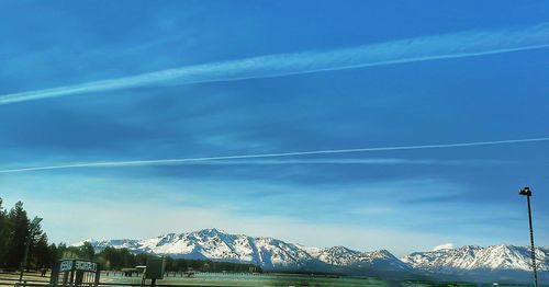 Scenic view of snowcapped mountains against blue sky