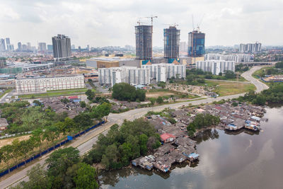 High angle view of buildings by river against sky