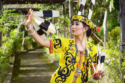 Woman in costume standing at forest