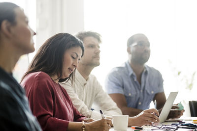 Male and female coworkers listening business plan in meeting at board room