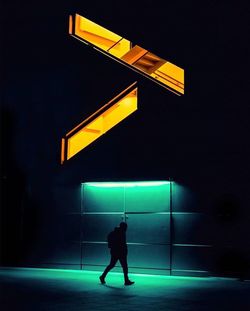 Full length of a man standing on illuminated road