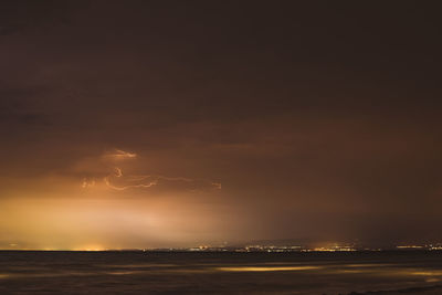 Lightning over sea against sky at night