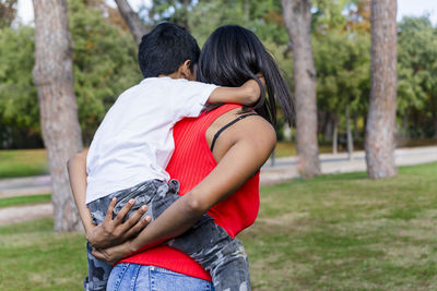 Happy mother and son enjoying together outdoors in a park.