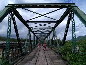 Rear view of man walking on footbridge