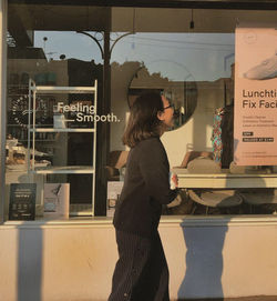 Side view of woman looking at store