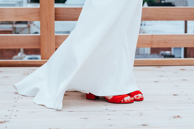 Low section of woman standing on wooden floor