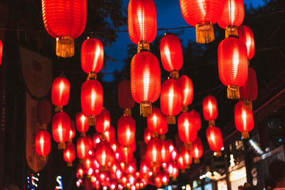 Low angle view of illuminated lanterns hanging at night