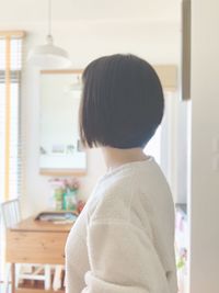 Rear view of woman standing at home