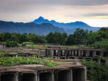 Built structure against trees and mountains against sky