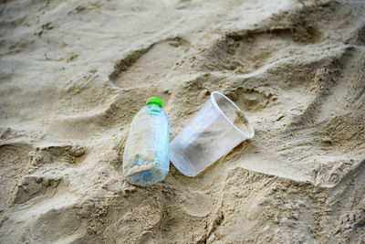 High angle view of bottle on sand at beach