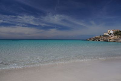 Scenic view of beach against cloudy sky