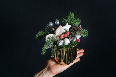 Cropped hand of woman holding christmas tree