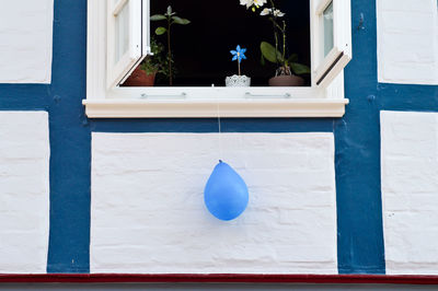 Blue balloon hanging from window