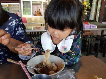 High angle view of girl having food on table