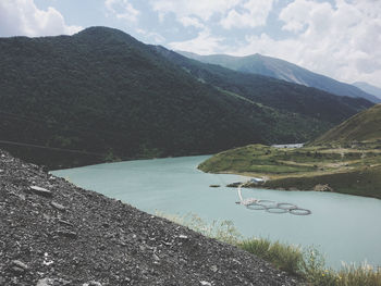 Scenic view of lake by mountains against sky