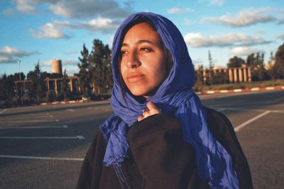 Woman wearing scarf while looking away in city