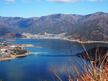 Scenic view of sea and mountains against blue sky