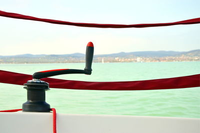 Close-up of rope handle on boat in sea against sky