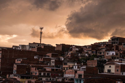 Buildings in city against sky at sunset